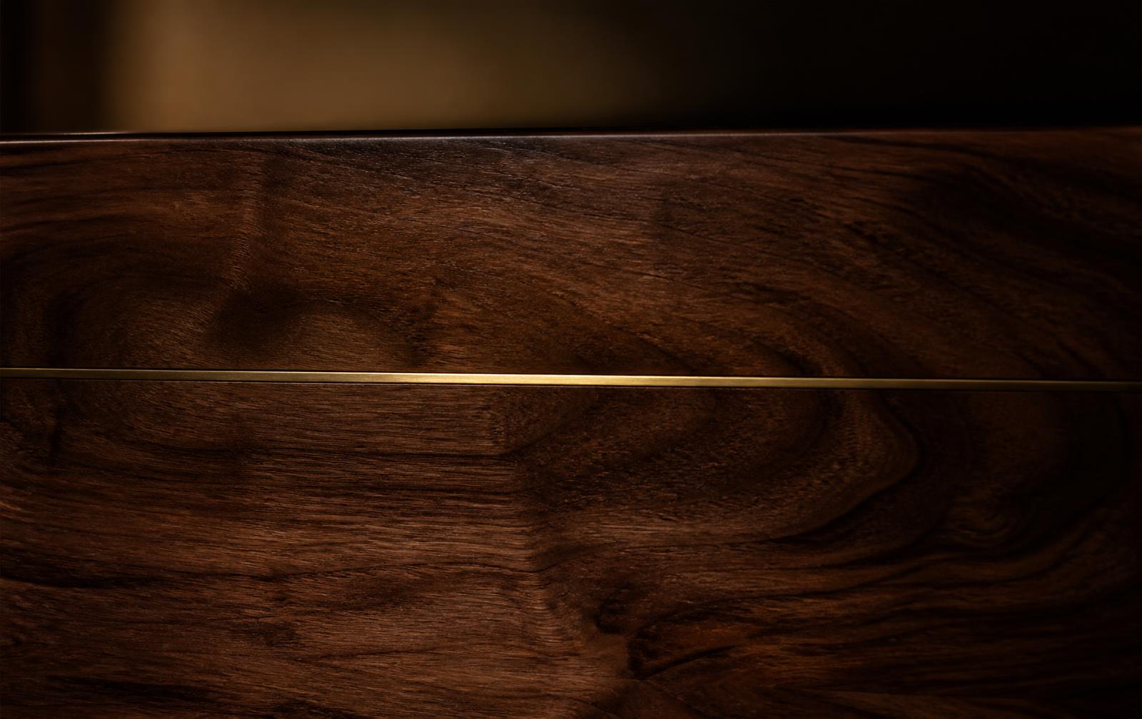 Deep walnut wood grain with a single inlaid brass line